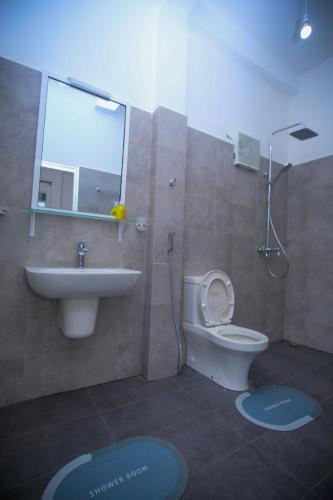 a bathroom with a sink and a toilet and a mirror at Ella Nimal Nest Inn in Ella
