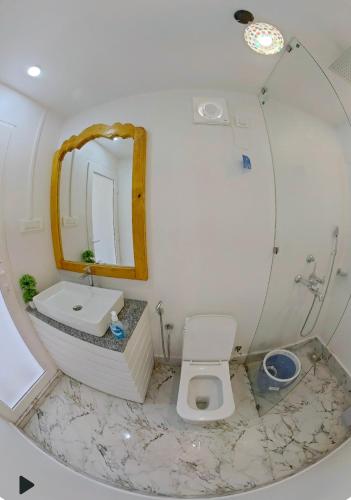 e bagno con specchio, servizi igienici e lavandino. di Pacific Sunset View Palolem a Palolem