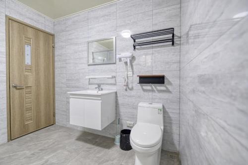 a bathroom with a toilet and a sink at Shijianhai B&B in Magong