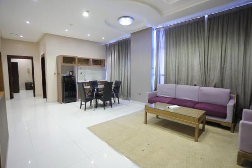 a living room with a purple couch and a table at Dar Hashim Serviced Apartments Al Morouj - Economic in Riyadh