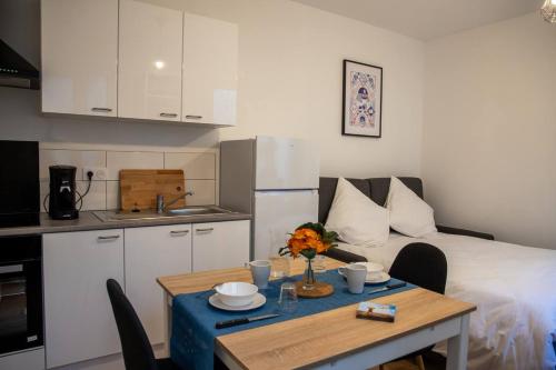 Cette chambre comprend une table, un lit et une cuisine. dans l'établissement La Tulipe - Confortable - un véritable cocon, à Niort