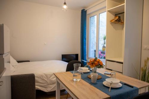 une chambre avec un lit et une table à manger et une chambre avec un lit dans l'établissement La Tulipe - Confortable - un véritable cocon, à Niort