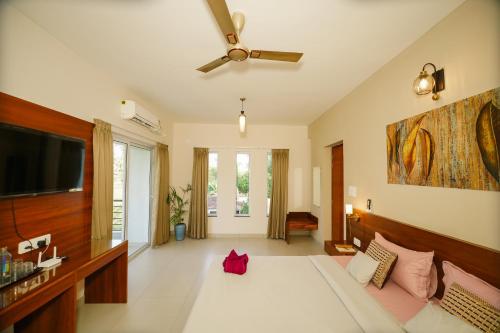 a bedroom with a large bed and a flat screen tv at Casa Das Imras Villa B in Calangute