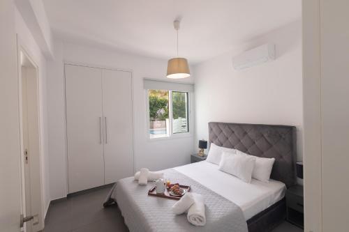 a bedroom with a bed with a tray of food on it at Casa de Nicole in Protaras