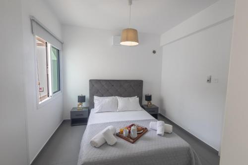 a bedroom with a bed with a tray of food on it at Casa de Nicole in Protaras