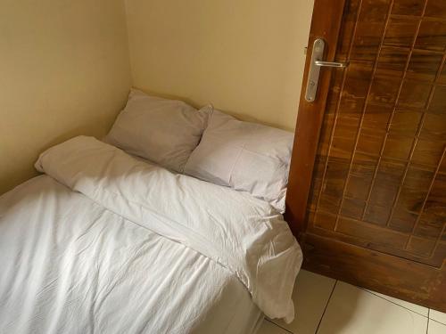 an unmade bed in a corner of a room at Prahu Dinar Syariah - Family in Lembang