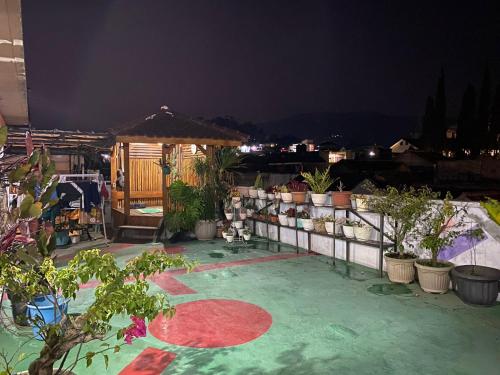 a patio with potted plants and a gazebo at night at Prahu Dinar Syariah - Family in Lembang