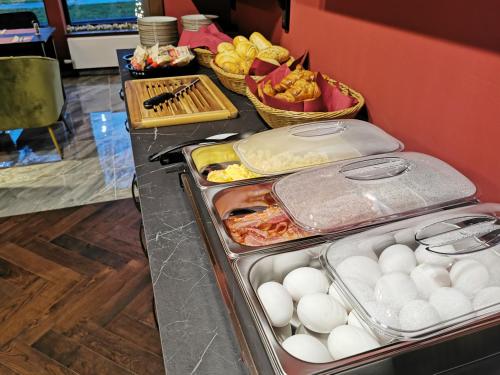a buffet with eggs and other food on a counter at Hotel Parkzicht in Valkenburg