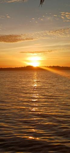 a sunset over a body of water with the sun setting at Yefkabu Homestay Raja Ampat in Waisai