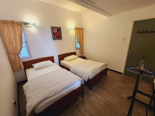 a room with two beds and a window at Little England B5 - Fraser Panorama in Bukit Fraser