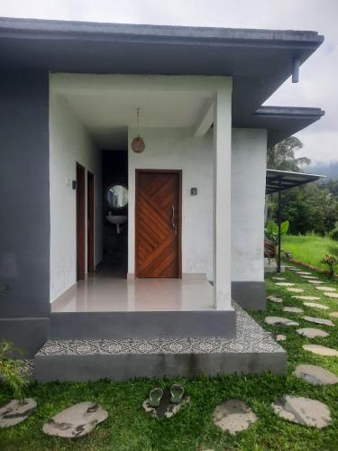 a house with a wooden door in a yard at VIP Homestay Lemukih in Singaraja