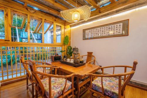 a dining room with a wooden table and chairs at Lijiang Lights Quiet Garden Desinger SerenityHaven Hotel B&B Gucheng Zhongyi Mufu Branch in Lijiang
