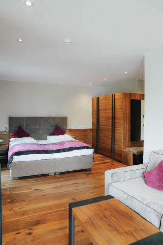 a bedroom with a bed and a couch at Hotel Restaurant Kirchsteiger in Vollan