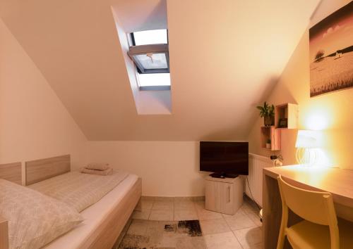 a bedroom with a bed and a desk with a television at Apartmány Pelech in Trenčianske Teplice
