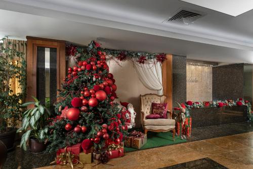 a christmas tree in a living room with presents at Spa Hotel Calista in Starozagorski Bani