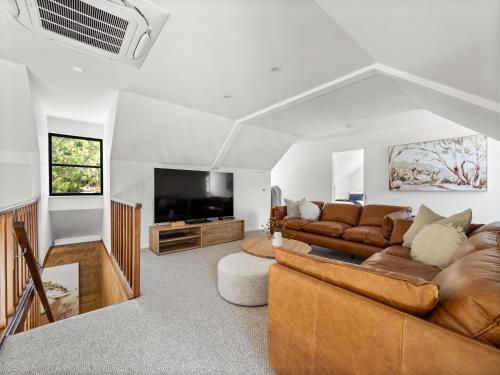 a living room with two couches and a flat screen tv at By the River - idyllic getaway in Margaret River Town