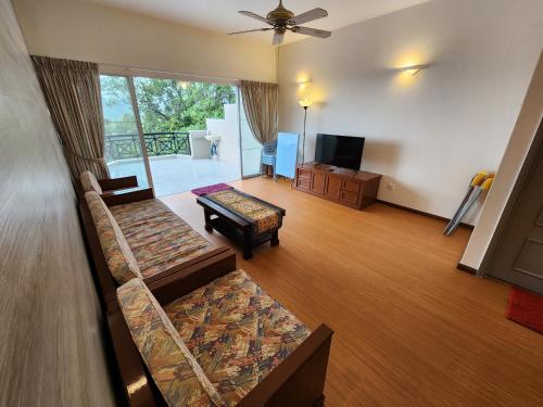 a living room with two couches and a television at Little England B8-3 in Bukit Fraser