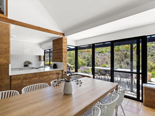 an open kitchen and dining room with a wooden table and chairs at By the River - idyllic getaway in Margaret River Town