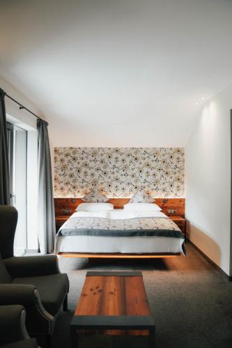 a bedroom with a large bed and a couch at Hotel Restaurant Kirchsteiger in Vollan