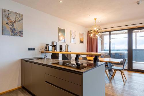a kitchen with a counter top and a dining room at Bergresort Hauser Kaibling by ALPS RESORTS in Haus im Ennstal