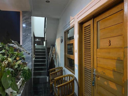 a stairway with two chairs and a wooden door at Prahu Dinar Syariah - Family in Lembang