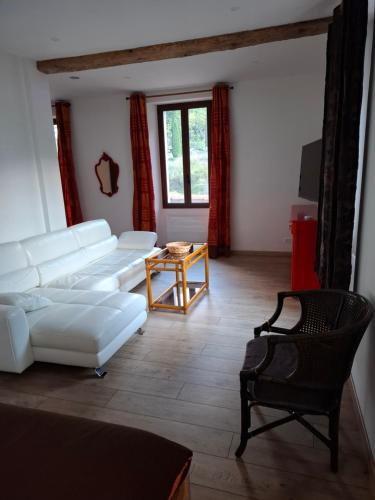 a living room with a white couch and a table at Appart au Pied du Mercantour in Fontan