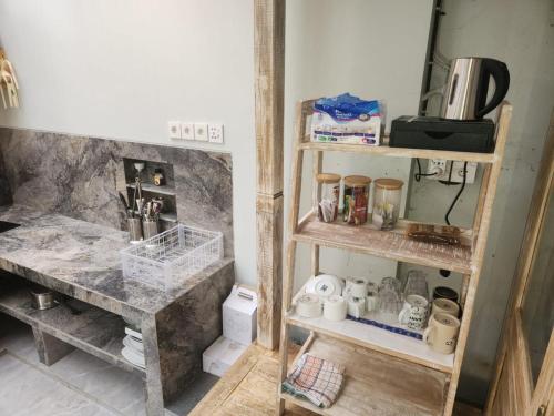 cocina con estanterías de madera y encimera en una habitación en Pondok Canaha, en Nusa Dua
