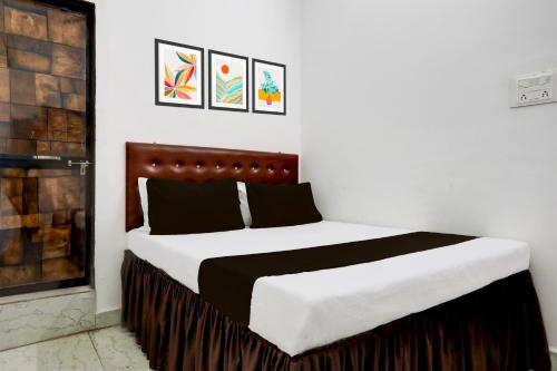 a bedroom with a bed with white and black at Hotel O Basera Lodging in Nagpur