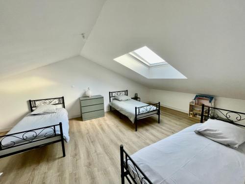 Schlafzimmer im Dachgeschoss mit 2 Betten und einem Dachfenster in der Unterkunft La maison aux volets bleus in Pornic