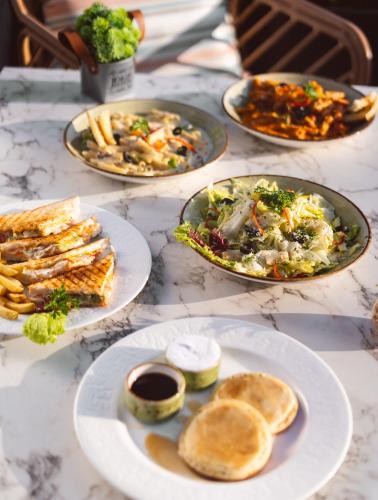 une table garnie d'assiettes de nourriture et de pain dans l'établissement Villasita Resort, à Kankhal