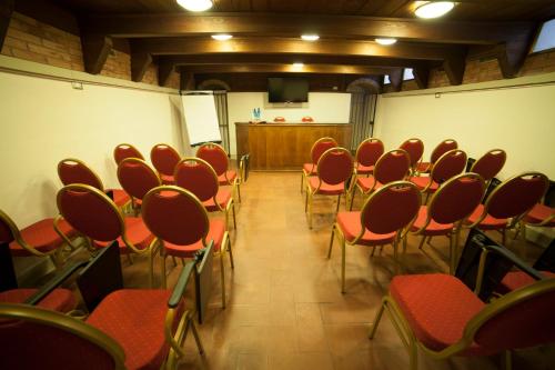 a conference room with red chairs and a podium at Hotel Gran Duca in Livorno