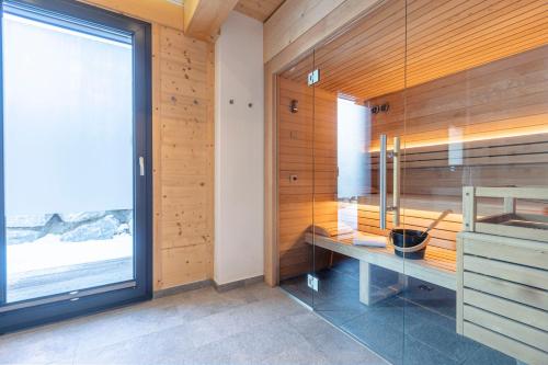 a sauna with a bench in a room with a window at Bergresort Hauser Kaibling by ALPS RESORTS in Haus im Ennstal