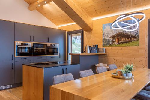 a kitchen with a wooden table and a wooden ceiling at Bergresort Hauser Kaibling by ALPS RESORTS in Haus im Ennstal