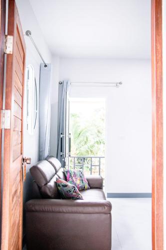 a brown couch in a room with a window at Relax home in Ao Nang 