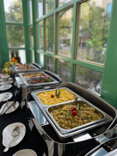 een buffet lijn met verschillende dienbladen eten op een tafel bij Nordic Resort in Manamah