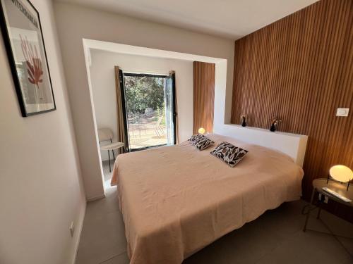 un dormitorio con una cama y una ventana en Casa 115, en Pianottoli-Caldarello