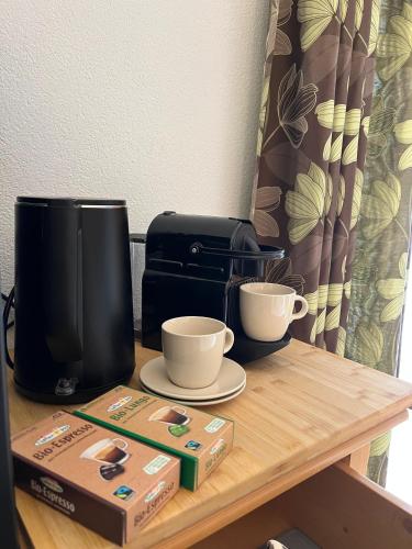 a wooden table with two cups and a coffee maker at Badererhof Christine Wechselberger in Stumm