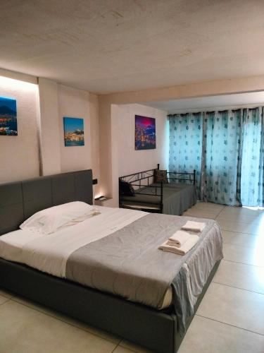 a bedroom with a large bed with blue curtains at Affittacamere airport orio Bergamo in Orio al Serio