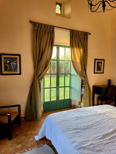 a bedroom with a bed and a large window at Private Villa at Jardins de Touhina in Marrakesh