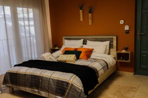 a bedroom with a large bed with orange walls at D&D rooms Nafplio in Nafplio