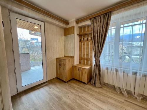 an empty room with a large window and a door at Green Park Guest House in Dilijan