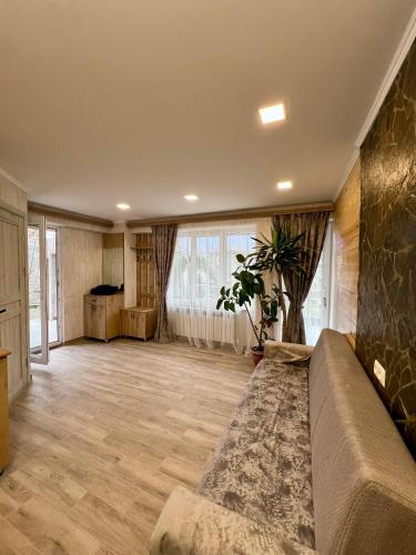 a living room with a couch and a large window at Green Park Guest House in Dilijan