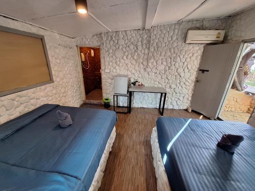 a bedroom with two blue beds and a table at Slumberland at Pai in Pai