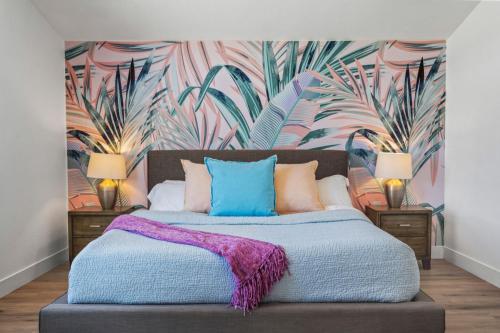 a bedroom with a large bed with a tropical wallpaper at Private Pool & Hot Tub, Games, Firepit by MariamsBnb in Indio