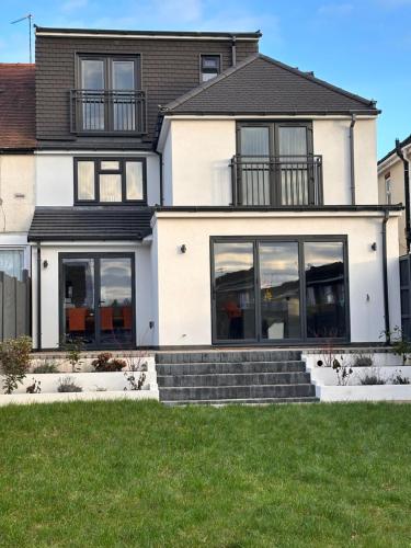 ein Haus mit großen Fenstern und grünem Gras in der Unterkunft R3 - Luxury Private Room With its own Kitchenette in Halesowen in Hasbury