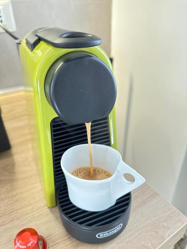 a coffee maker is pouring coffee into a cup at Dimora Sant Anna in Piacenza