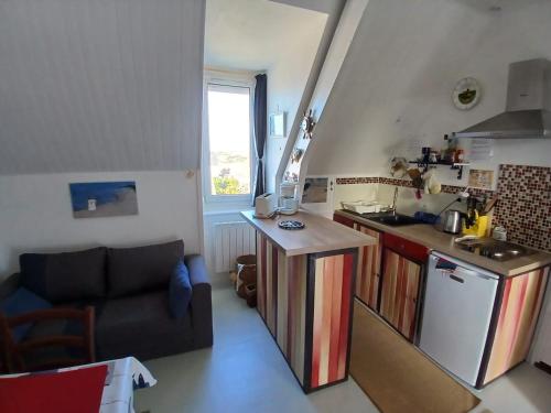 - une petite cuisine avec un canapé et un comptoir dans l'établissement Petit bijou à Saint Pair sur Mer, à Saint-Pair-sur-Mer