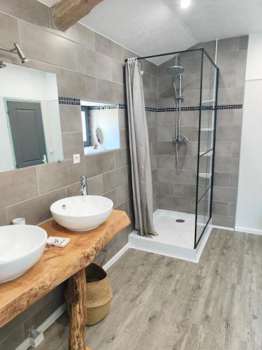 une salle de bain avec deux lavabos et une douche dans l'établissement La bordette, à Sauveterre