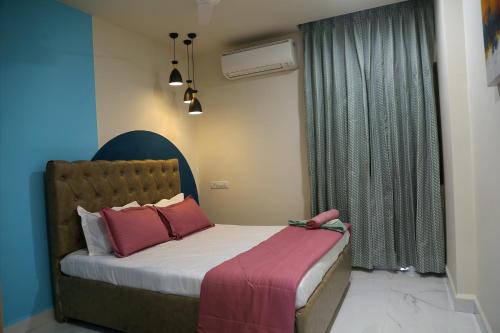 ハイデラバードにあるCozy 3 bhk A/C home @ wipro circle , Near US Embassyのベッドルーム1室(ピンクの枕が付くベッド1台、窓付)