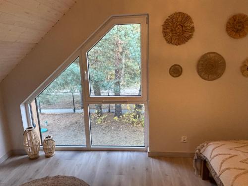 an attic room with a large window and a bed at Dom Na Brzegu Ciszy in Pasym